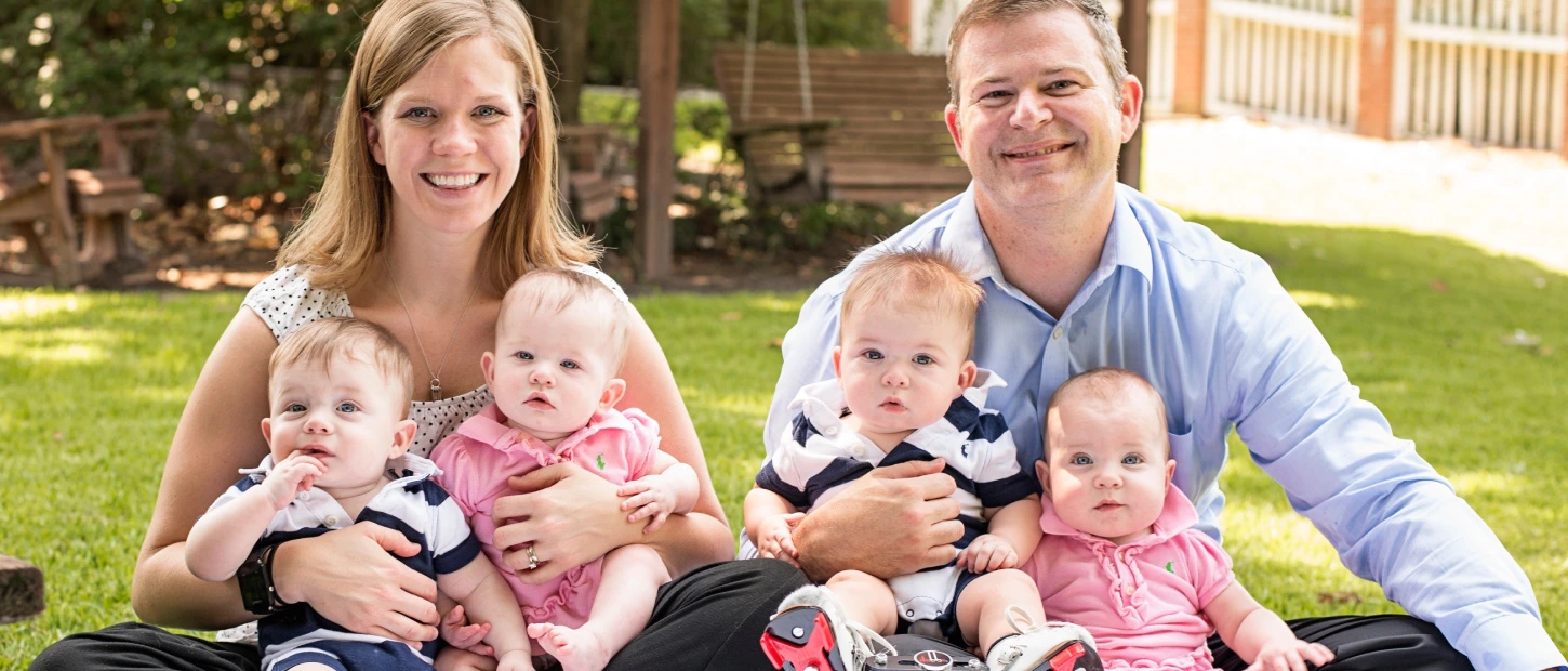 A mother and father with their four small newborn babies
