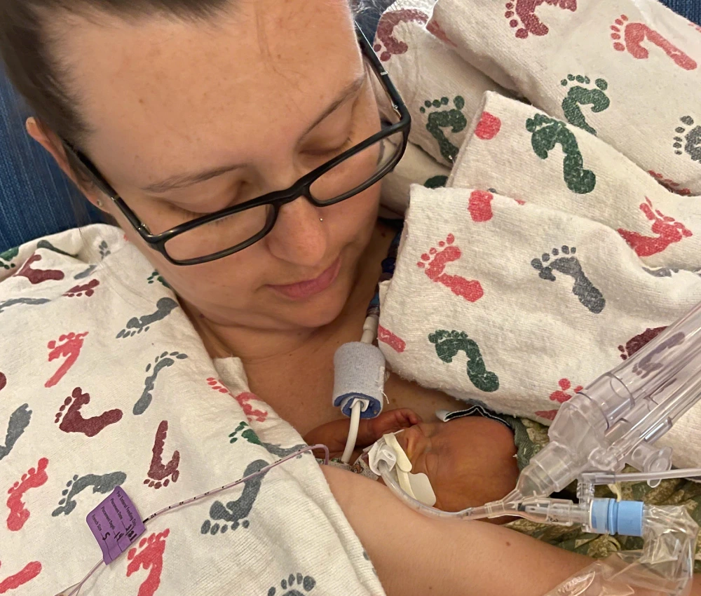 mother holding her newborn baby to her chest