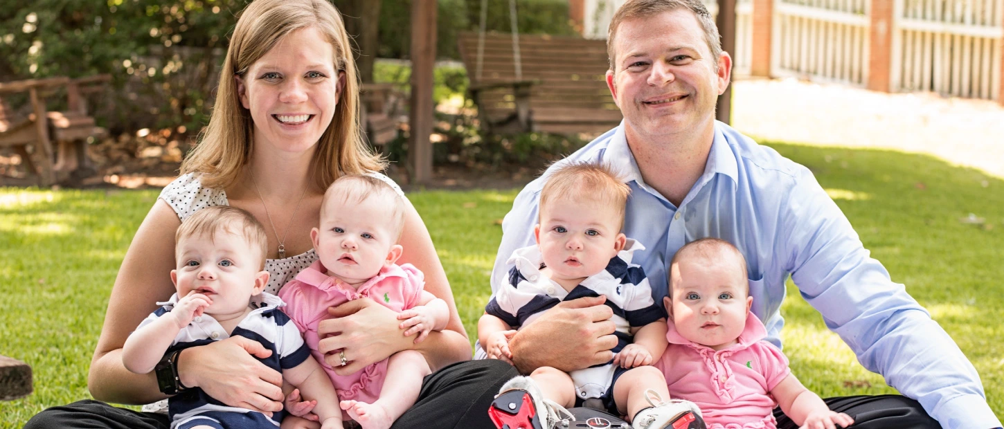 A mother and father with their four small newborn babies