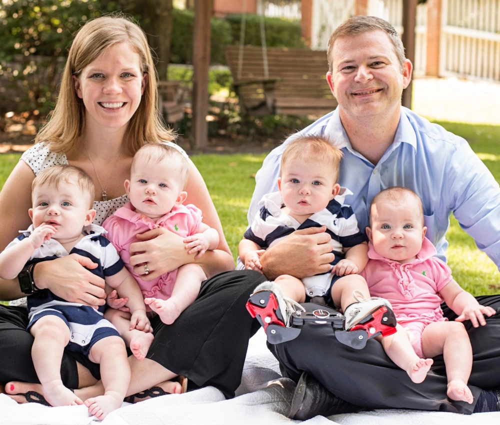 A mother and father with their four small newborn babies