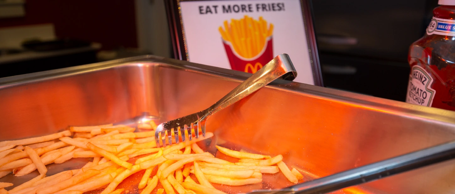 tray of french fries and serving tongs